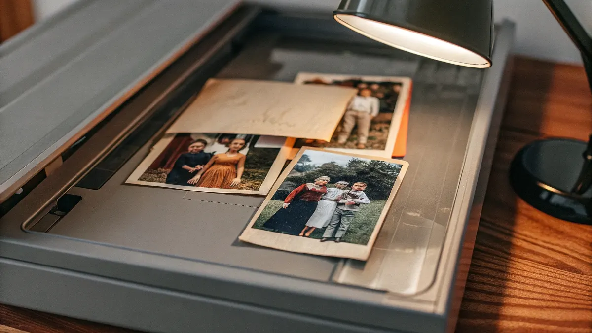 Flatbed scanner with vintage family photographs and handwritten letters being digitized